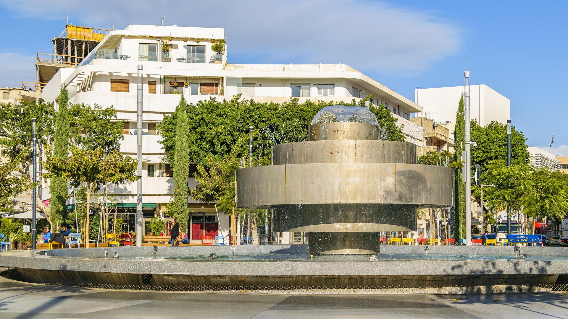 Menschen in Tel Aviv, Israel, sitzen an einem Brunnen und sprechen miteinander Menschen in Tel Aviv, Israel, sitzen an einem Brunnen und sprechen miteinander