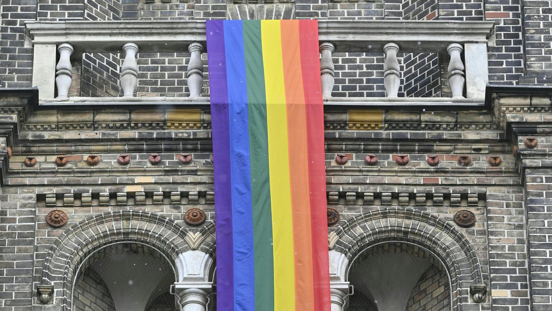 Eine Regenbogenfahne hängt an der Pfarrkirche Breitenfeld in Wien.