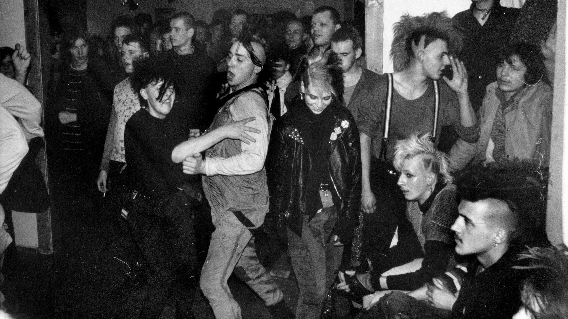 Tanzende Punks auf einem Punkkonzert (Schwarzweißaufnahme) Tanzende Punks auf einem Punkkonzert (Schwarzweißaufnahme)