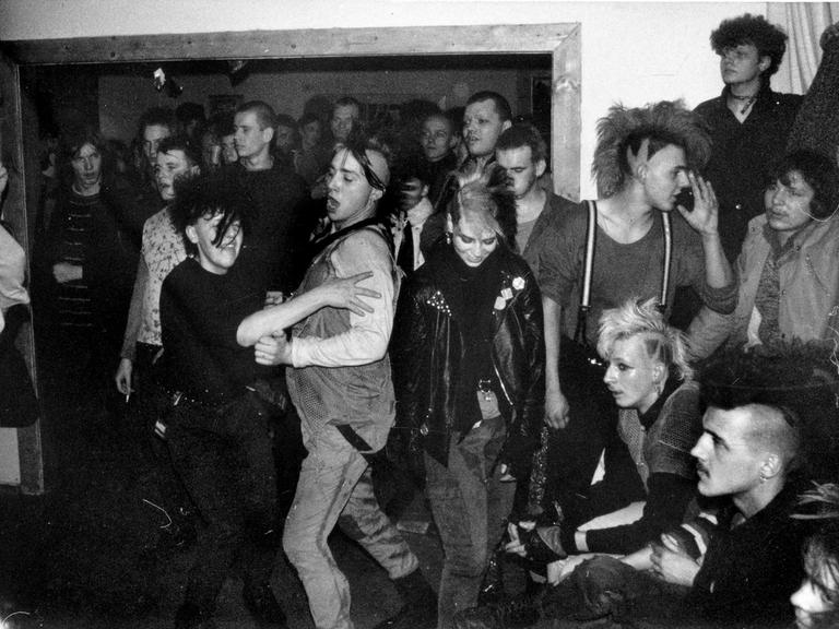Tanzende Punks auf einem Punkkonzert (Schwarzweißaufnahme)
