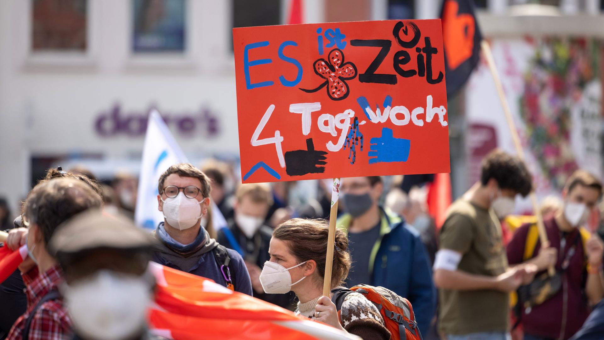Eine Demonstrantin fordert bei einer DGB-Kundgebung 2021 Erfurt zum 1. Mai auf ihrem Plakat die 4-Tage-Woche.