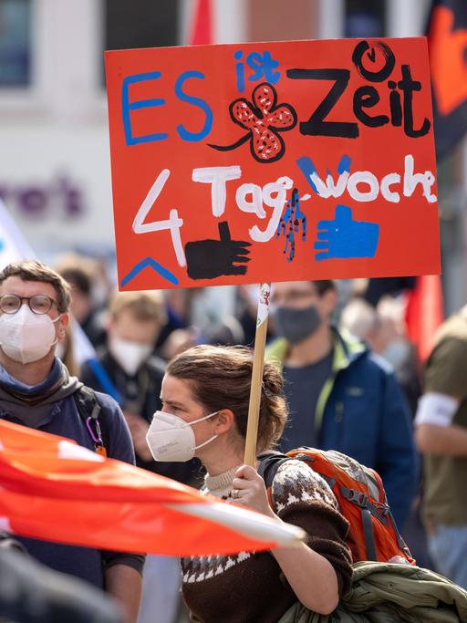 Eine Demonstrantin fordert bei einer DGB-Kundgebung 2021 Erfurt zum 1. Mai auf ihrem Plakat die 4-Tage-Woche.