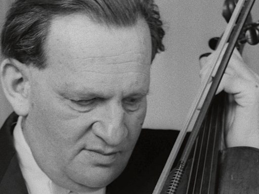 Auf dem s/w Bild ist ein Porträt eines Mannes zu sehen, der eine Bratsche in der Hand hält und nach unten schaut.