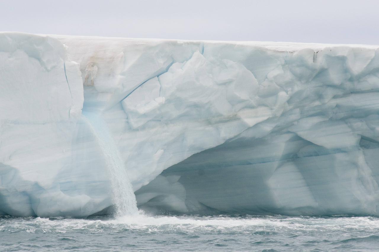 Von einem arktischen Gletscher fließt Schmelzwasser in den Ozean. Von einem arktischen Gletscher fließt Schmelzwasser in den Ozean.