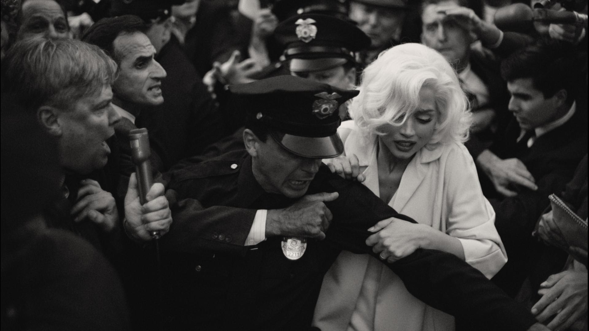 Die Filmszene in Schwarz-Weiß zeigt, wie Marilyn Monroe von einem Polizisten abgeführt wird. Die Filmszene in Schwarz-Weiß zeigt, wie Marilyn Monroe von einem Polizisten abgeführt wird.