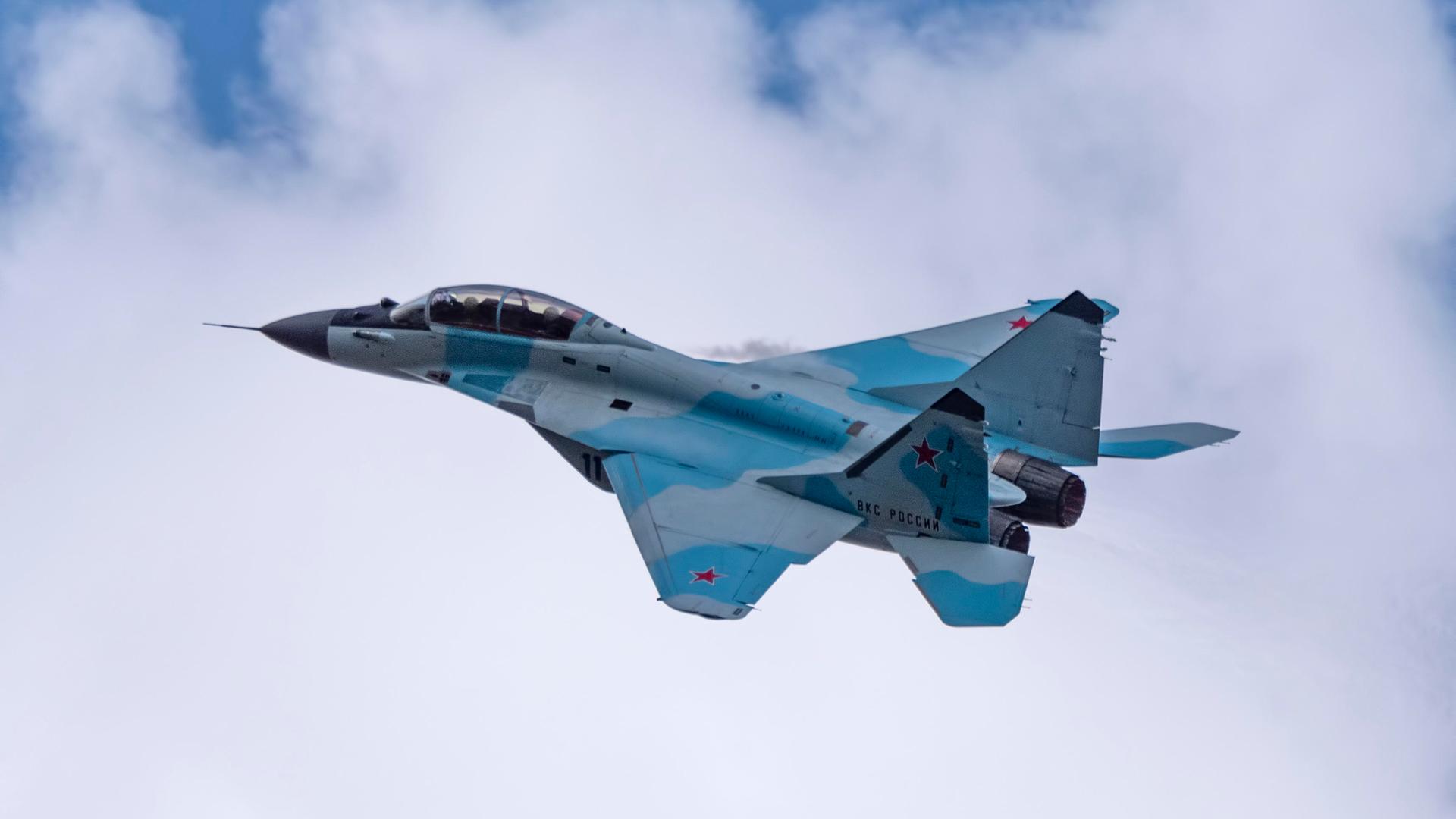 Russischer Kampfjet fliegt vor weißen Wolken am Himmel Russischer Kampfjet fliegt vor weißen Wolken am Himmel