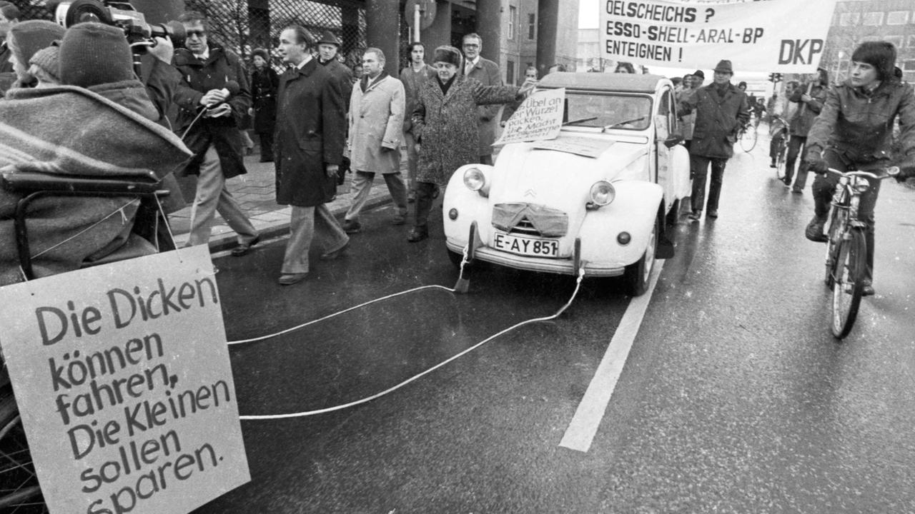 Autokorso der DKP am 24.11.1973 in Essen gegen die Fahrverbote an den autolosen Sonntagen . Die Fahrzeuge wurden jedoch von Menschen und Pferden gezogen und geschoben. Auf einem Schild ist zu lesen: "Die Dicken können fahren, die Kleinen sollen sparen." Autokorso der DKP am 24.11.1973 in Essen gegen die Fahrverbote an den autolosen Sonntagen . Die Fahrzeuge wurden jedoch von Menschen und Pferden gezogen und geschoben. Auf einem Schild ist zu lesen: "Die Dicken können fahren, die Kleinen sollen sparen."