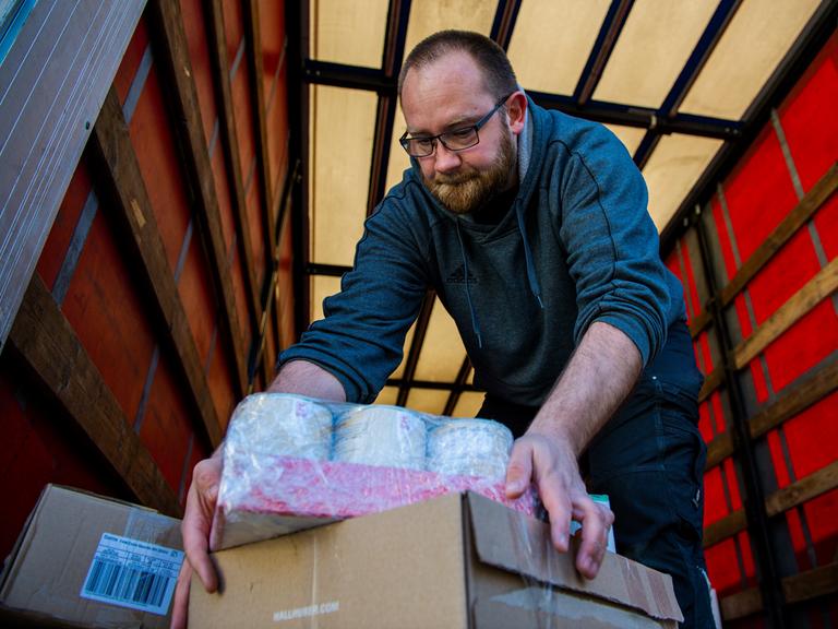 Ein Helfer belädt einen Lastwagen für einen Hilfskonvoi für die Ukraine. 