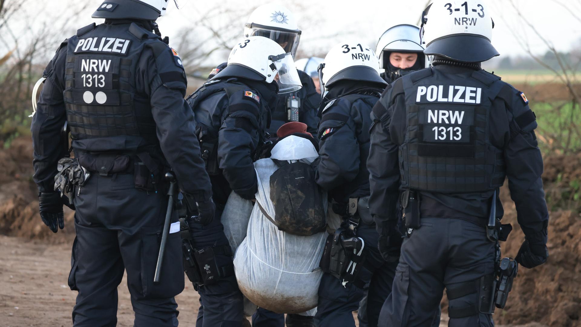 Ein Klimaschutzaktivist wird in Lützerath von der Polizei weggetragen. Lützerath soll zur Erweiterung des Braunkohletagebaus Garzweiler II abgebaggert werden. Ein Klimaschutzaktivist wird in Lützerath von der Polizei weggetragen. Lützerath soll zur Erweiterung des Braunkohletagebaus Garzweiler II abgebaggert werden.