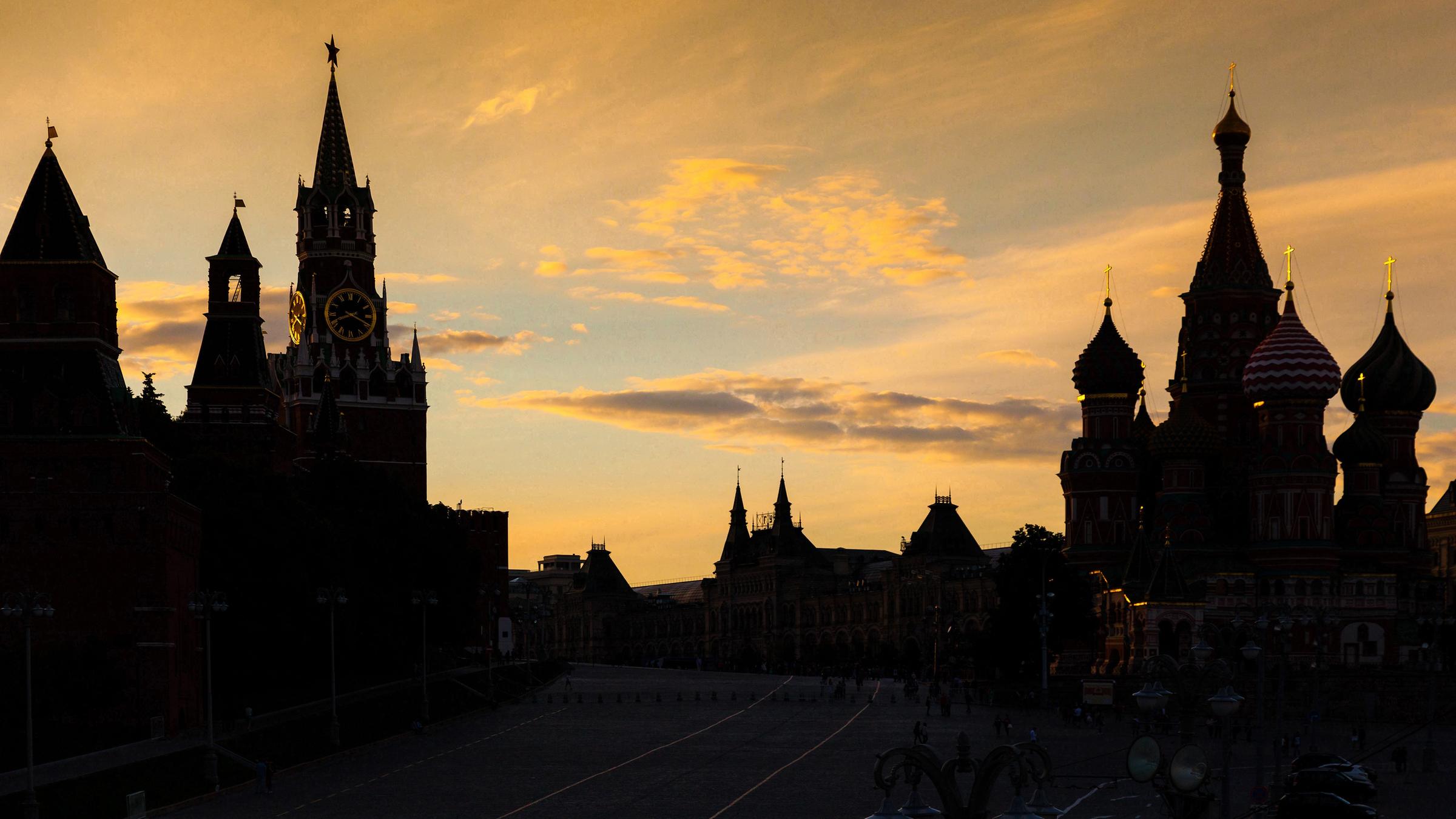 Roter Platz bei Abenddämmerung in Moskau. Links der Kreml, rechts die Basilius- Kathedrale.