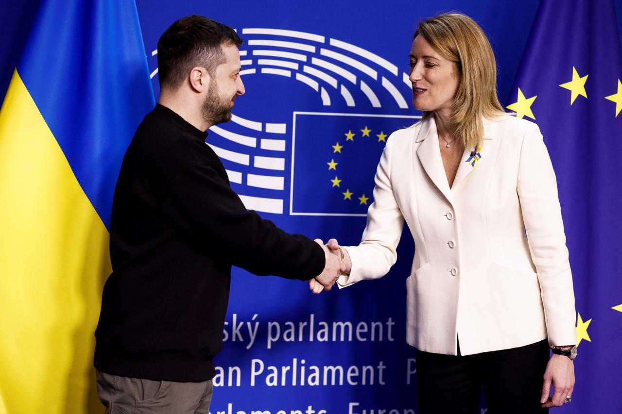 Der ukrainische Präsident Selenskyj wird im EU-Parlament in Brüssel von der Präsidentin des Europäischen Parlaments, Metsola, begrüßt. Sie schütteln sich die Hände.