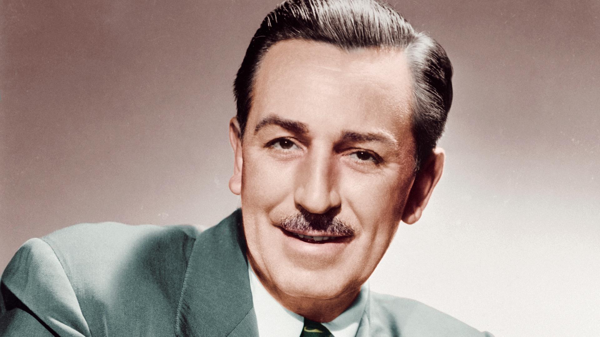 Porträt von Walt Disney, sitzend mit gefalteten Händen.