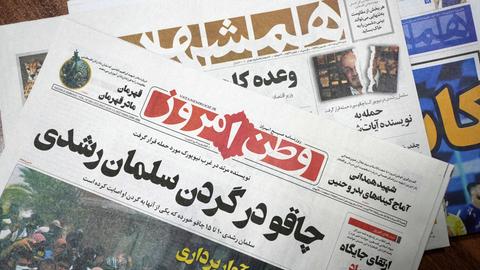 Titelseiten von iranischen Zeitungen am 13. August: Vatan-e Emrooz (vorne): "Messer im Nacken von Salman Rushdie", und Hamshahri (hinten), mit dem Titel: "Angriff auf den Autor der Satanischen Verse".