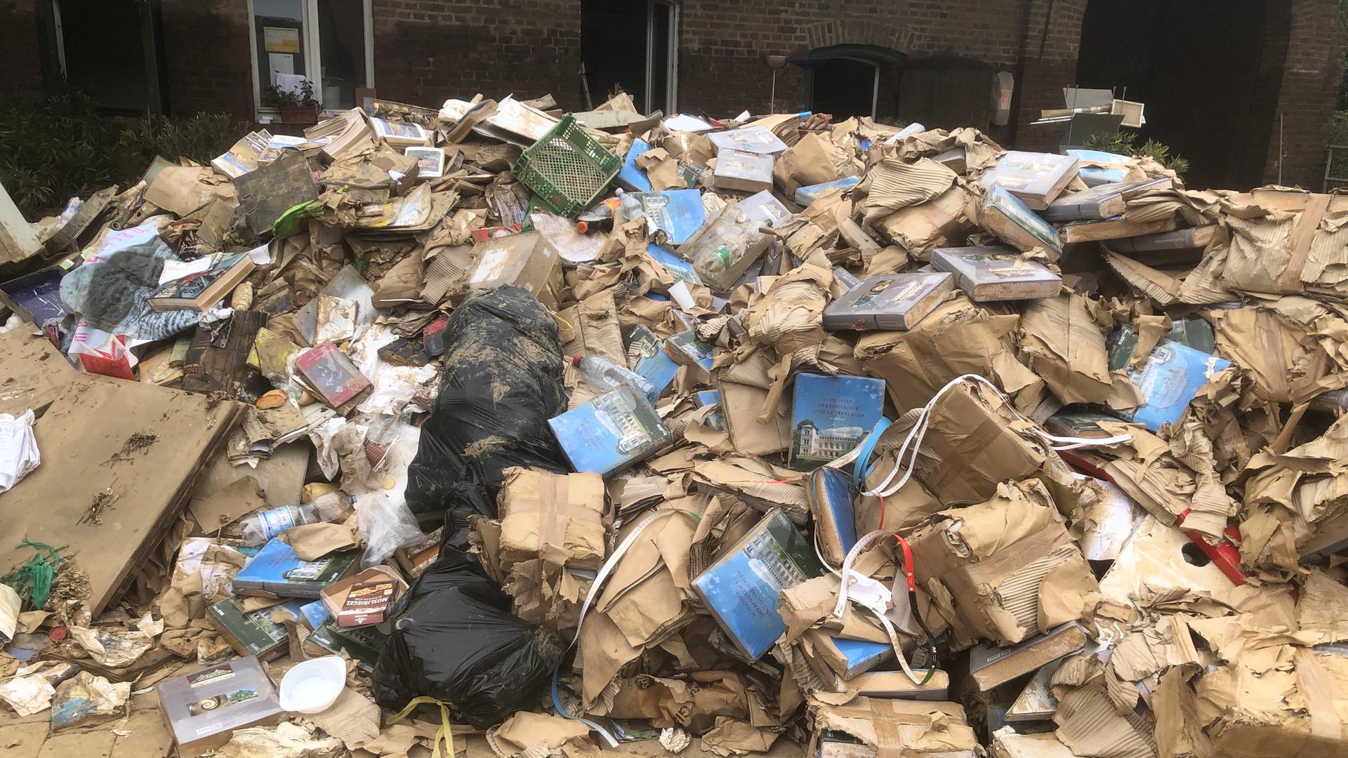 Mit Schlamm bedeckte Bücher liegen auf einem Haufen Mit Schlamm bedeckte Bücher liegen auf einem Haufen