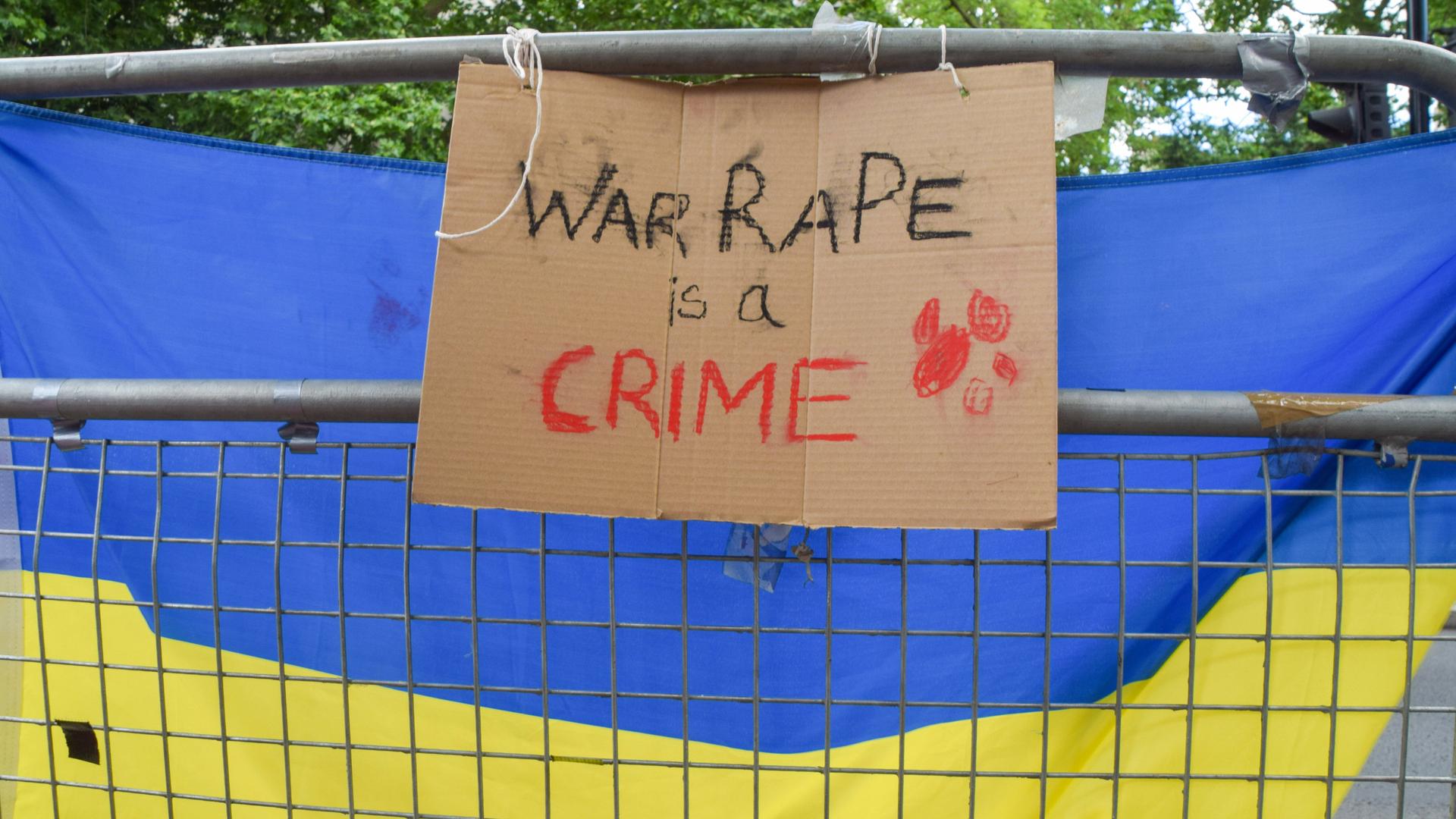 Flagge mit der Aufschrift "War Rape is A Crime" als Protest gegen die Vergewaltigung als Kriegswaffe im russischen Angriffskrieg gegen die Ukraine in London, Großbritannien am 28. Mai 2022