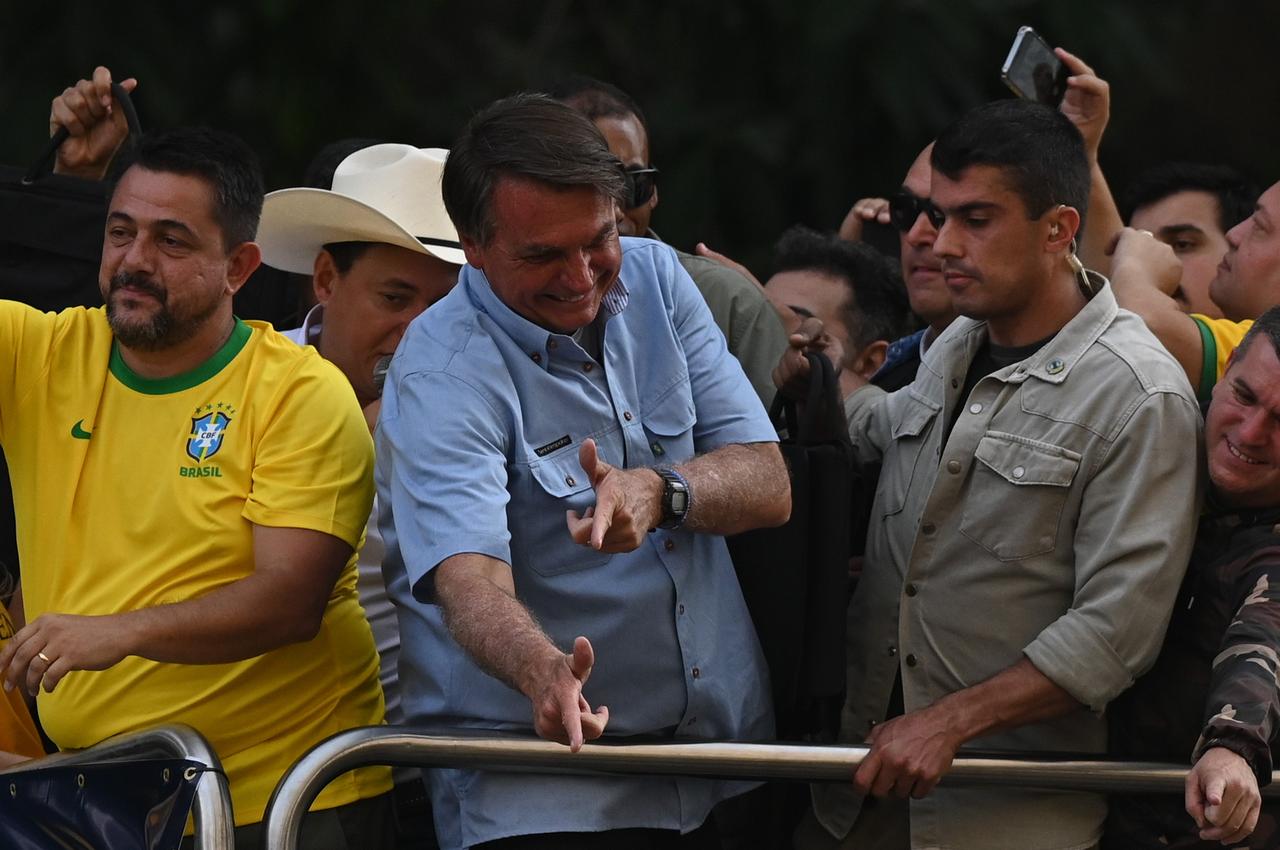 Jair Bolsonaro (M.), damals noch Präsident von Brasilien, scherzt mit Anhängern nach einer Rede am Tag der Unabhängigkeit im Jahr 2021 und macht ein für ihn typisches Zeichen: Er formt seine Hände zu einer Pistole.