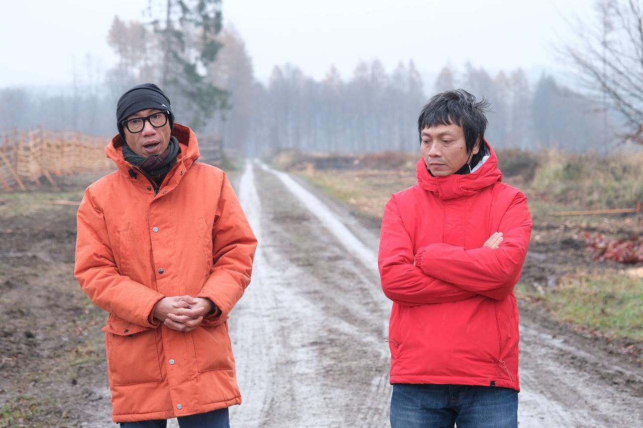 Iswanto Hartono und Reza Afisina von der Künstlergruppe Ruangrupa tragen orange Anoraks, hinter ihnen ist ein Forstweg zu sehen. Iswanto Hartono und Reza Afisina von der Künstlergruppe Ruangrupa tragen orange Anoraks, hinter ihnen ist ein Forstweg zu sehen.