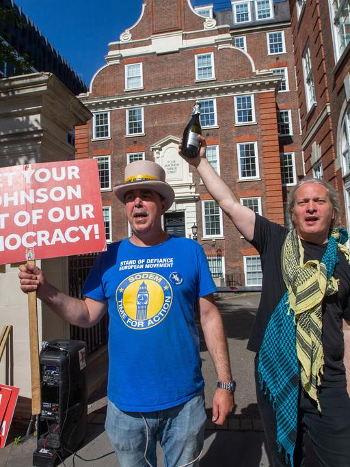 Zwei Anti-Boris-Johnson-Demonstranten feiern die Niederlagen der Torys in den Wahlkreisen Devon und Wakefield bei Nachwahlen 