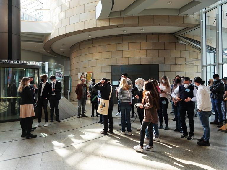 Geflüchtete stehen im Landtag. Sie besuchen im Rahmen des Programms "Demokratieschule" den nordrhein-westfälischen Landtag. 