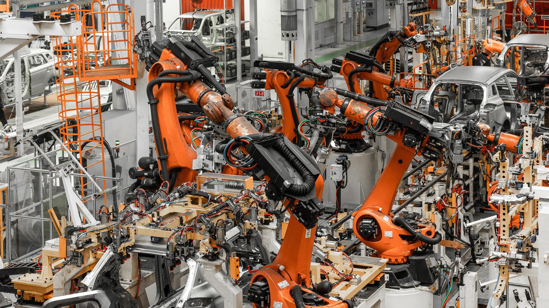 Blick in die Produktionshalle eines Automobilherstellers mit vielen Geräten und Robotern.