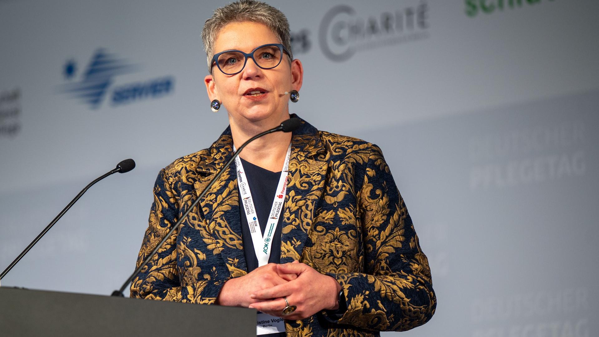 Christine Vogler, Präsidentin des Deutschen Pflegerates, steht vor einem Mikrofon.