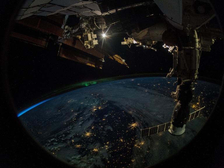 Die Erde gesehen von der ISS mit einem Satellitensystem im Vordergrund, Foto von Alexander Gerst, 2018.