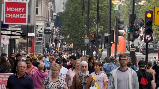 Großbritannien, London: Menschen gehen entlang einer Einkaufsstraße.