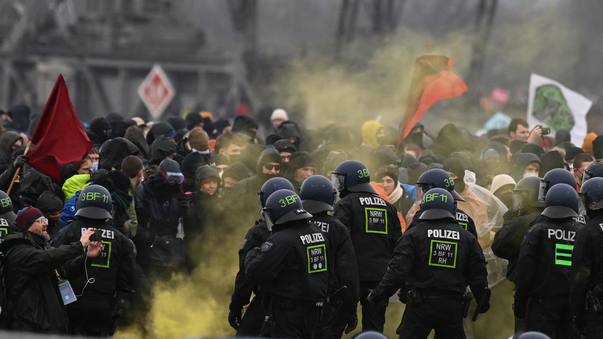 Demonstranten stehen der Polizei in Lützerath gegenüber. RWE will die unter Lützerath liegende Kohle abbaggern - dafür soll der Weiler auf dem Gebiet der Stadt Erkelenz am Braunkohletagebau Garzweiler II abgerissen werden. Demonstranten stehen der Polizei in Lützerath gegenüber. RWE will die unter Lützerath liegende Kohle abbaggern - dafür soll der Weiler auf dem Gebiet der Stadt Erkelenz am Braunkohletagebau Garzweiler II abgerissen werden.