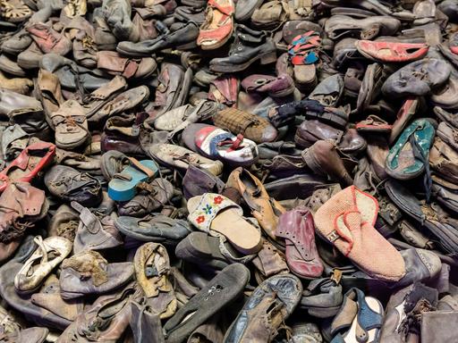 Schuhe von Opfern des Holocaust im ehemaligen Konzentrationslager Auschwitz. Sie liegen durcheinander auf einem Haufen.