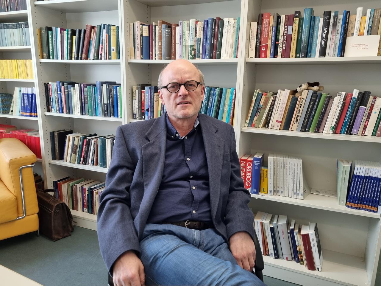 Der Religionsphilosoph und Theologe Heiko Schulz vor seinem Bücherregal.