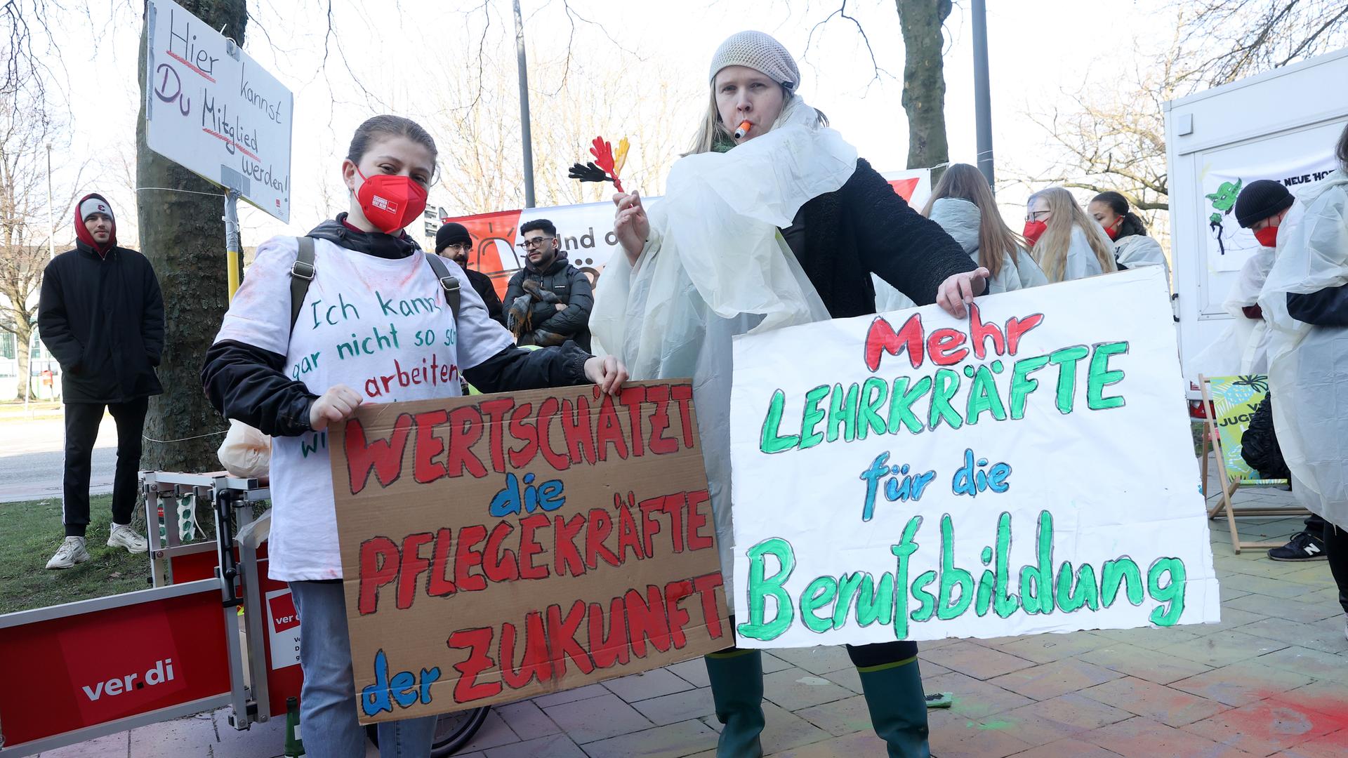 Teilnehmer eines bundesweiten Jugendstreiktags von Auszubildenden und dual Studierenden im öffentlichen Dienst demonstrieren vor dem Gewerkschaftshaus. Dabei halten zwei Teilnehmerinnen Schilder mit den Aufschriften Â«Wertschätzt die Pflegekräfte der ZukunftÂ» und Â«Mehr Lehrkräfte für die BerufsbildungÂ». Verdi fordert in der laufenden Tarifrunde eine Erhöhung der Ausbildungs- und Studienvergütungen um 200 Euro monatlich.