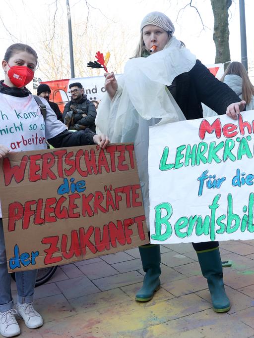 Teilnehmer eines bundesweiten Jugendstreiktags von Auszubildenden und dual Studierenden im öffentlichen Dienst demonstrieren vor dem Gewerkschaftshaus. Dabei halten zwei Teilnehmerinnen Schilder mit den Aufschriften Â«Wertschätzt die Pflegekräfte der ZukunftÂ» und Â«Mehr Lehrkräfte für die BerufsbildungÂ». Verdi fordert in der laufenden Tarifrunde eine Erhöhung der Ausbildungs- und Studienvergütungen um 200 Euro monatlich.