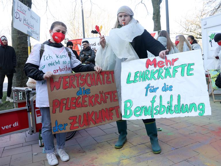Teilnehmer eines bundesweiten Jugendstreiktags von Auszubildenden und dual Studierenden im öffentlichen Dienst demonstrieren vor dem Gewerkschaftshaus. Dabei halten zwei Teilnehmerinnen Schilder mit den Aufschriften Â«Wertschätzt die Pflegekräfte der ZukunftÂ» und Â«Mehr Lehrkräfte für die BerufsbildungÂ». Verdi fordert in der laufenden Tarifrunde eine Erhöhung der Ausbildungs- und Studienvergütungen um 200 Euro monatlich.