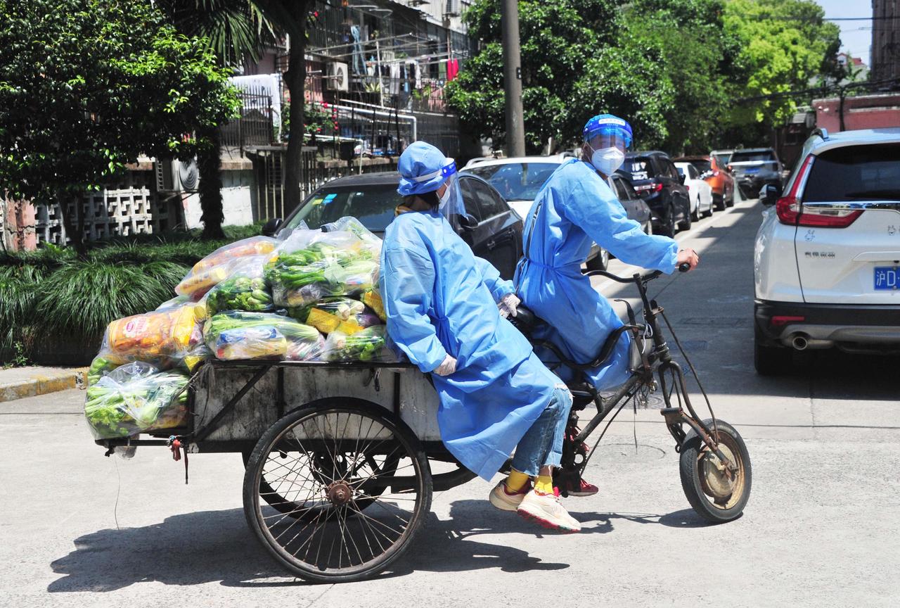 Freiwillige Helfer verteilen Lebensmittel an die Bewohner einer geschlossenen Wohnanlage während der stufenweisen Abriegelung aufgrund des COVID-19-Ausbruchs am 4. Mai 2022 in Shanghai. 