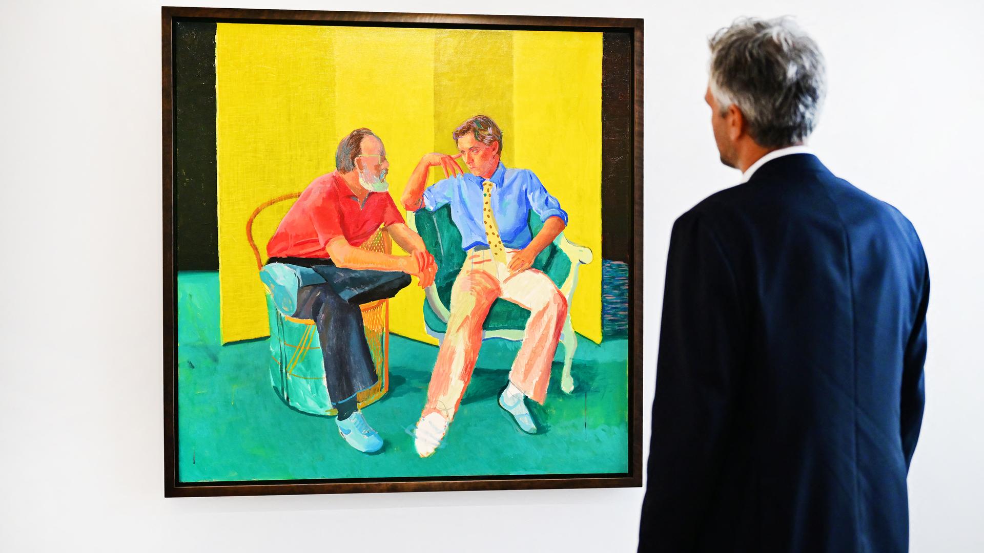 Alex Marshall, Vizepräsident von Christie's, steht vor dem Gemälde "The Conversation' von David Hockney.
