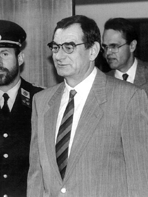 Der österreichische Aktionskünstler Otto Mühl (M) und sein Vertrauter Bernd Stein betreten in Begleitung von zwei Polizisten den Verhandlungsraum, aufgenommen am 13.11.1991. Im Landesgericht Eisenstadt beginnt am 13.11.1991 die für drei Tage geplante Hauptverhandlung gegen den 66jährigen Aktionskünstler und Gründer der Kommune "Friedrichshof" bei Zurndorf, Otto Mühl, und dessen Vertrauten, den 43jährigen Bernd Stein. Dem umstrittenen Kommunenoberhaupt werden zahlreiche Sittlichkeits- und Rauschgiftdelikte sowie Zeugenbeeinflussung vorgeworfen.