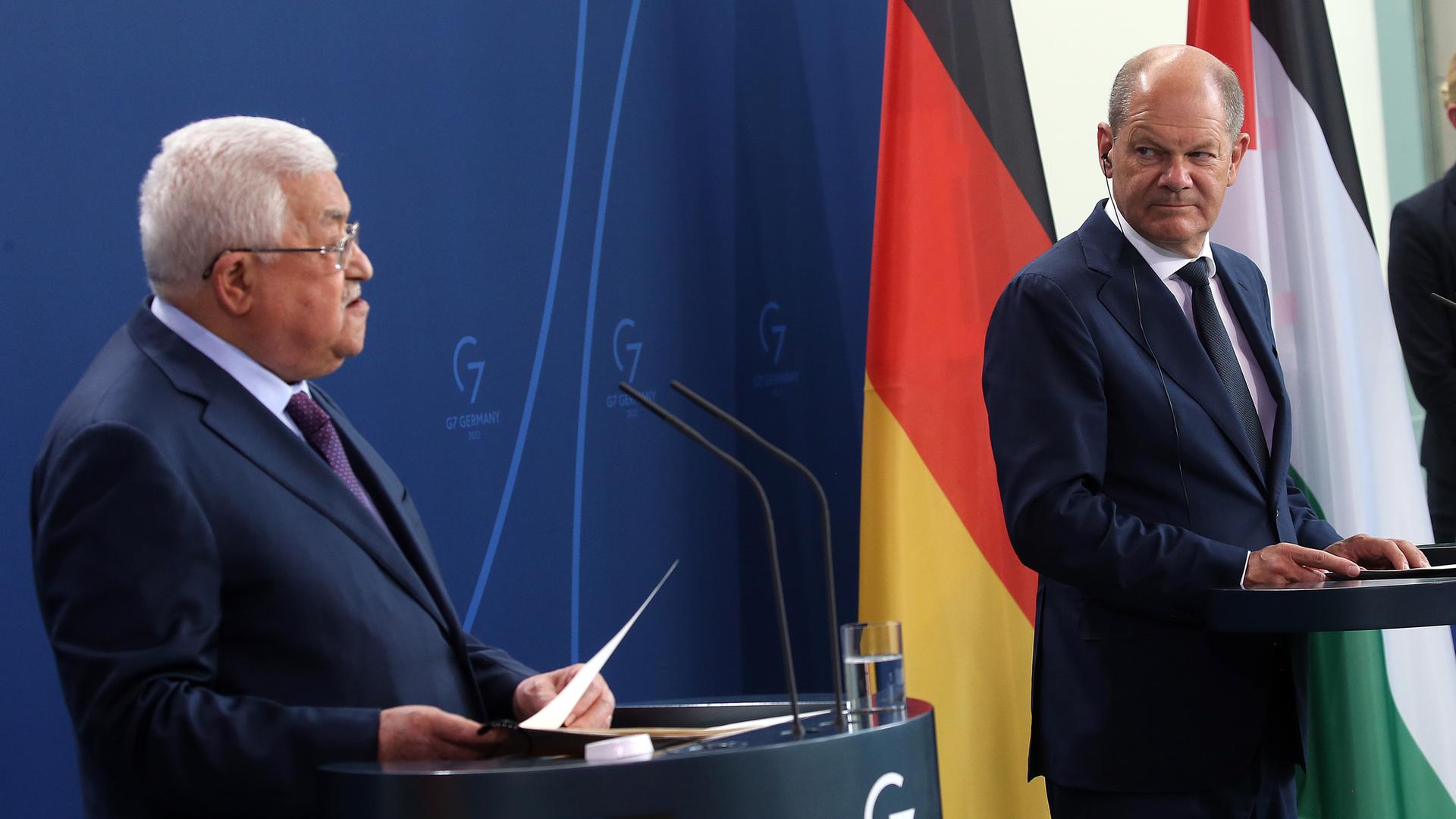 Mahmud Abbas und Bundes-Kanzler Olaf Scholz stehen nebeneinander. Abbas sagt etwas, Scholz schaut mit ernstem Blick zu. Mahmud Abbas und Bundes-Kanzler Olaf Scholz stehen nebeneinander. Abbas sagt etwas, Scholz schaut mit ernstem Blick zu.
