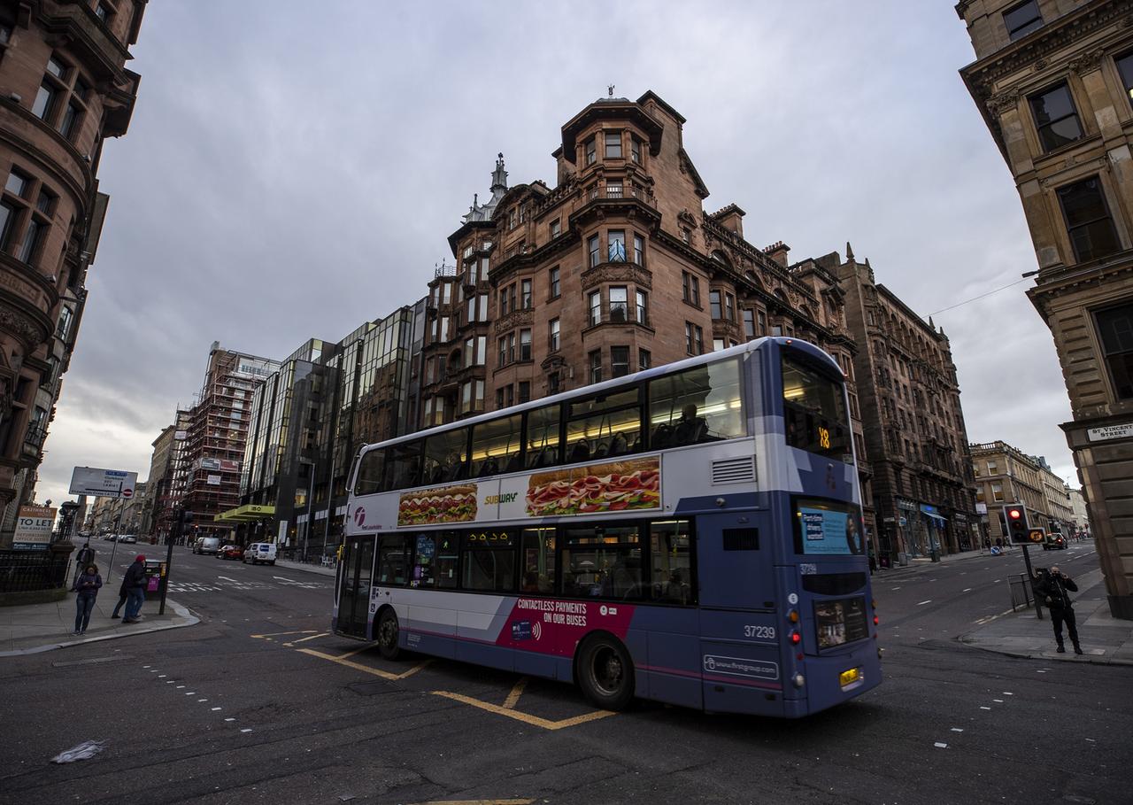 Ein Bus fährt durch eine Straße von Glasgow Ein Bus fährt durch eine Straße von Glasgow