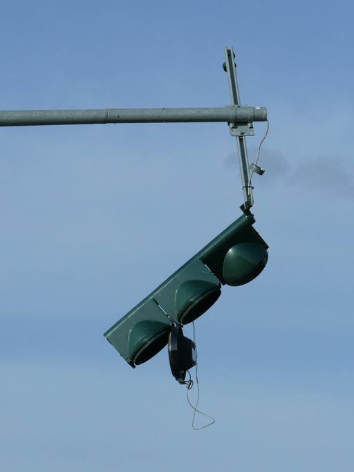 Nach einer Kollision ist eine Ampel kaputt und außer Betrieb. Sie hängt am Mast. 