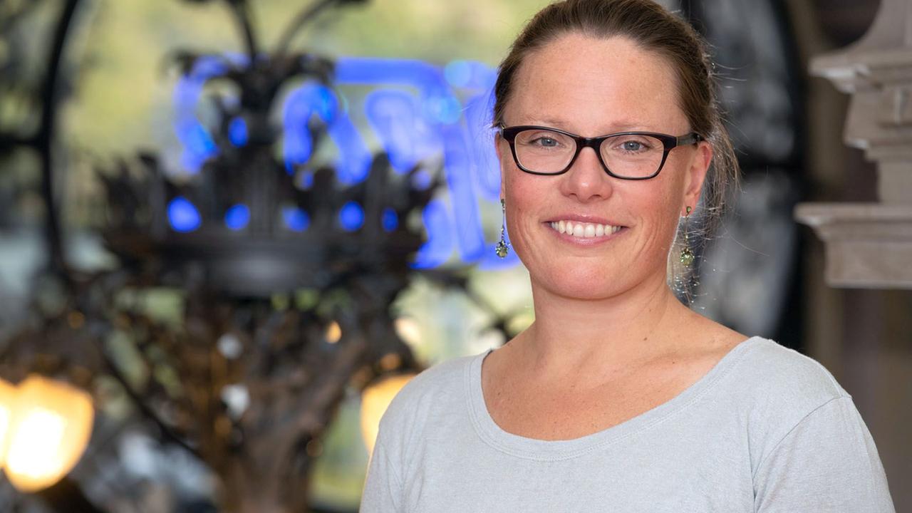 Ines Michalowski steht in einer Kirche und lächelt in die Kamera Ines Michalowski steht in einer Kirche und lächelt in die Kamera