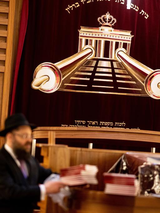 Gemeindemitglieder stehen zu Beginn des Pessach-Fests im Jüdischen Bildungszentrum Chabad Lubawitsch Berlin im Gebetsraum der Synagoge. 