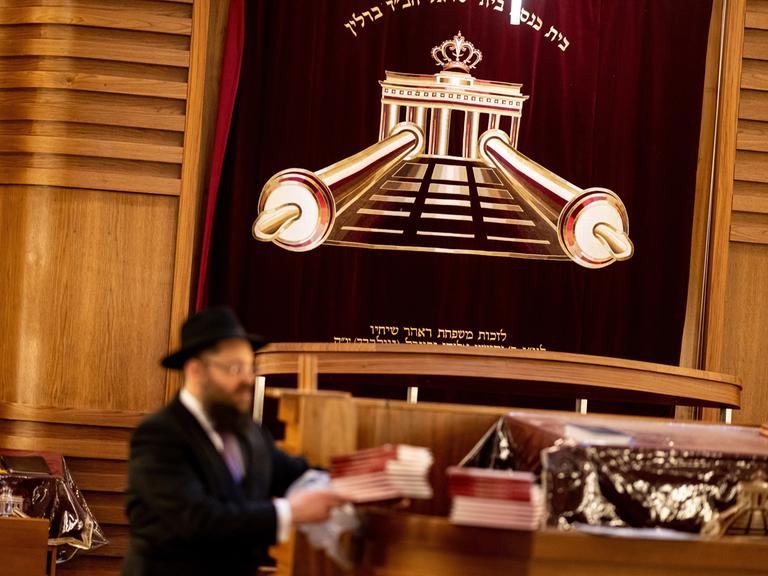 Gemeindemitglieder stehen zu Beginn des Pessach-Fests im Jüdischen Bildungszentrum Chabad Lubawitsch Berlin im Gebetsraum der Synagoge. 