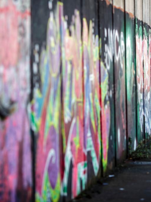 Ein Graffiti-Künstler besprüht im pro-britischen Teil von Belfast eine Friedensmauer