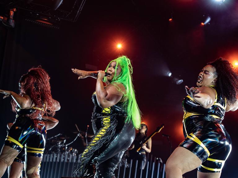 US-Sängerin Lizzo mit zwei Tänzerinnen bei einem Konzertauftritt in Rotterdam im Juni 2023