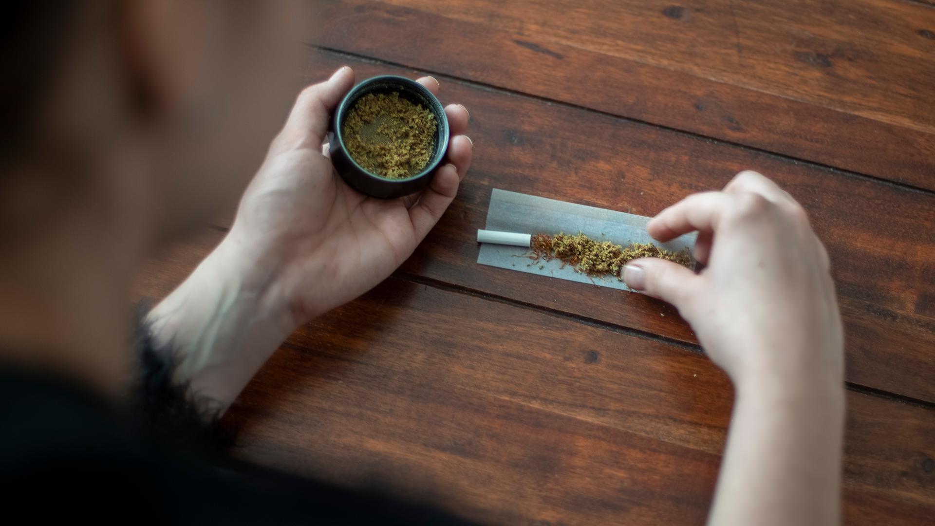 Eine Frau baut mit Marihuana einen Joint (Tüte). Zu sehen sind eine kleine Dose mit Marihuana und auf dem Tisch ein noch nicht gedrehter Joint. Copyright: Julia Imo/ picture alliance/photothek Eine Frau baut mit Marihuana einen Joint (Tüte). Zu sehen sind eine kleine Dose mit Marihuana und auf dem Tisch ein noch nicht gedrehter Joint. Copyright: Julia Imo/ picture alliance/photothek
