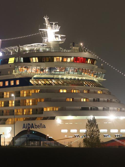 Hell erleuchtetes Kreuzfahrtschiff liegt im Hafen