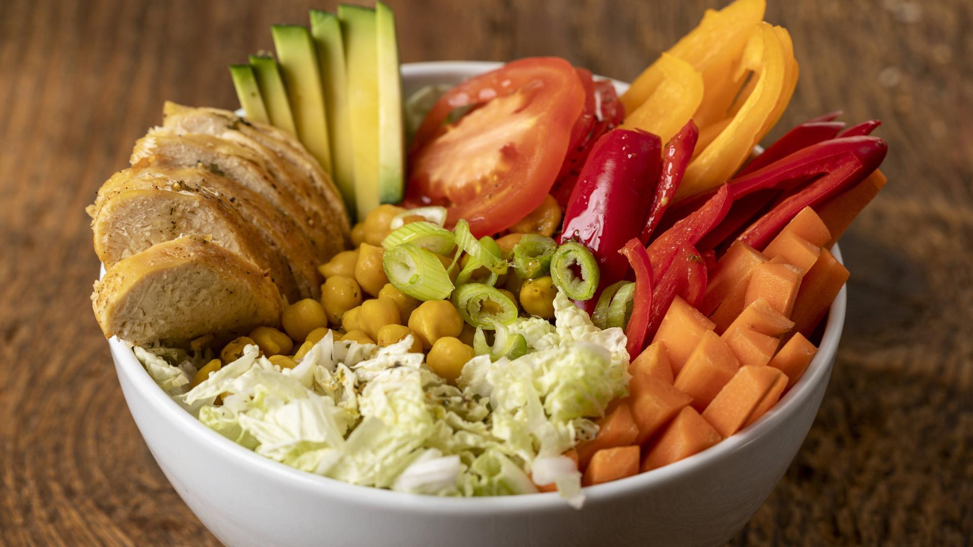 Buddha Bowl mit Hühnchen auf Holz Buddha Bowl mit Hühnchen auf Holz