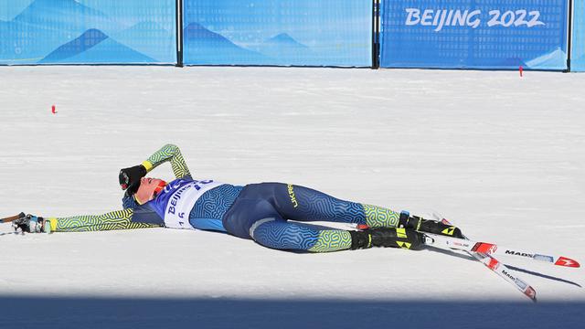 Der ukrainische Biathlet Serafim Drahun liegt erschöpft im Ziel.