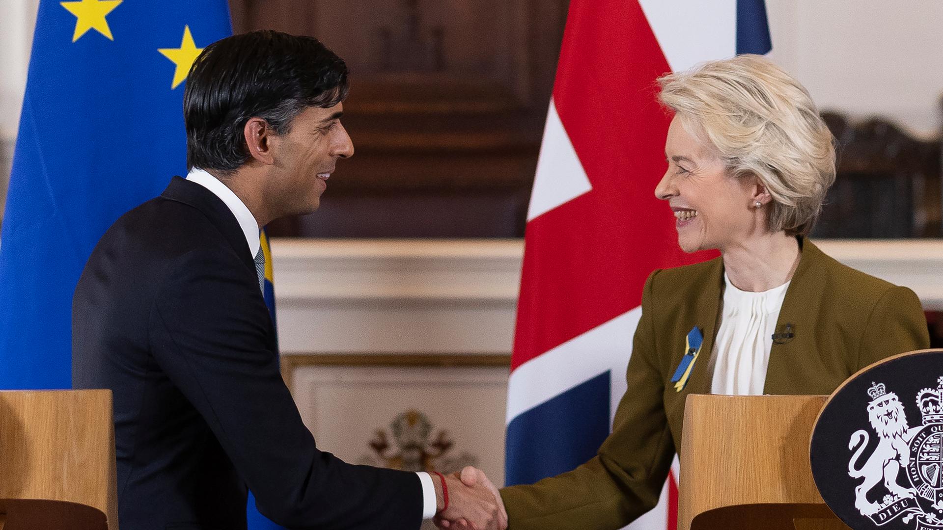 Der Regierungs-Chef von dem Land Groß-Britannien, Rishi Sunak, und die Präsidentin von der Europäischen Union, Ursula von der Leyen. Sie schütteln sich die Hände. Der Regierungs-Chef von dem Land Groß-Britannien, Rishi Sunak, und die Präsidentin von der Europäischen Union, Ursula von der Leyen. Sie schütteln sich die Hände.