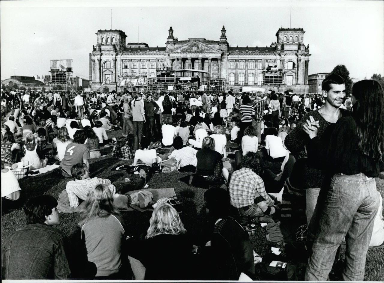 Eine Menschenmenge steht 1980 vor der Bühne vor dem Reichstag in Berlin bei einem Konzert von Barclay James Harvest Eine Menschenmenge steht 1980 vor der Bühne vor dem Reichstag in Berlin bei einem Konzert von Barclay James Harvest